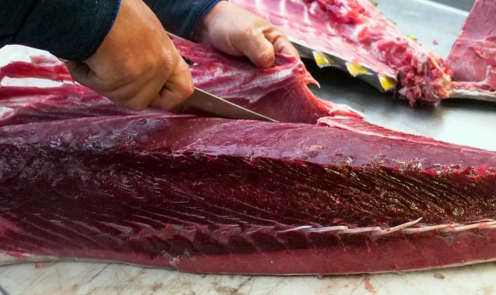 Een slager snijdt vlees - Foto door Kindel Media van Pexels