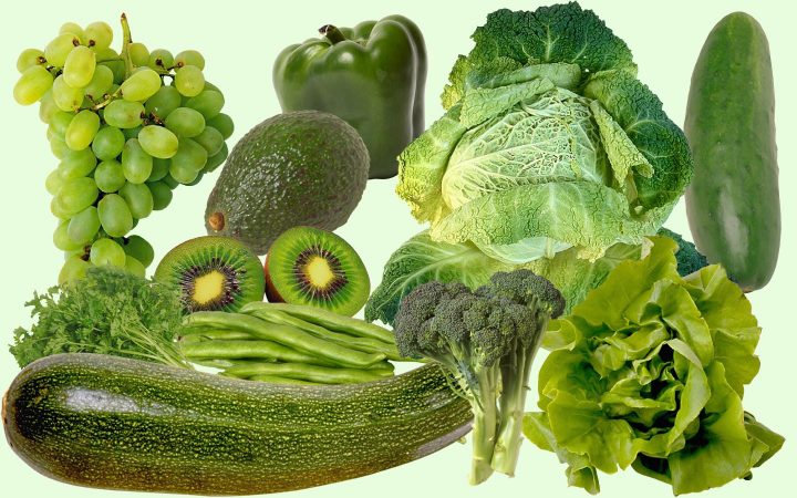 Een assortiment groene vruchten en groenten, waaronder courgette, komkommer, sla, kool, broccoli, snijbonen, paprika, avocado, kiwi en druiven.
