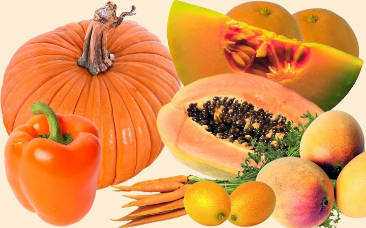Assortiment van oranje fruit en groenten, waaronder, pompoen, cantaloupe, sinaasappel, wortelen, mango's en paprika.