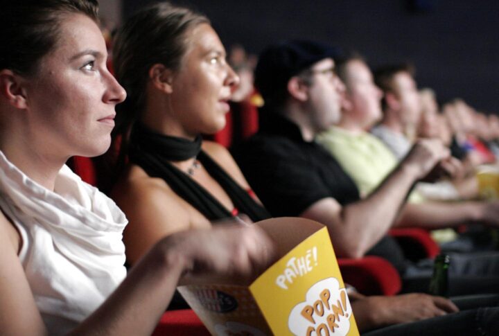 Een dame die popcorn in een bioscoop eet - Photo by rpb1001 on Flickr https://www.flickr.com/photos/rpb1001/257368762/