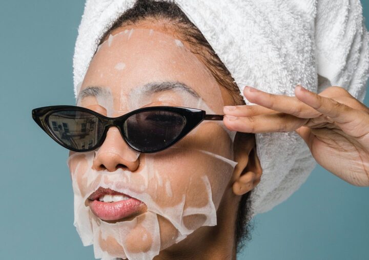 Een vrouw met een gezichtsmasker, haarbehandeling en zonnebril, die haar zelfvertrouwen probeert te verbeteren