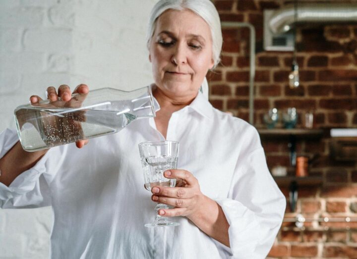 
Een oudere vrouw neemt een glas water