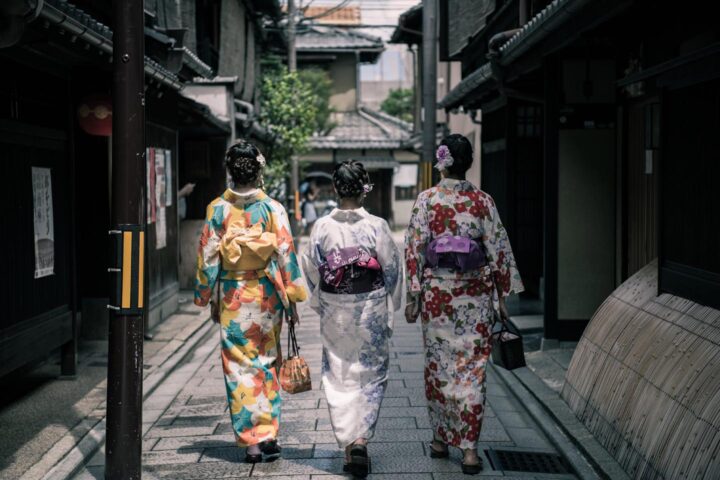 Drie Japanse dames in traditionele kleding wandelen door een straat