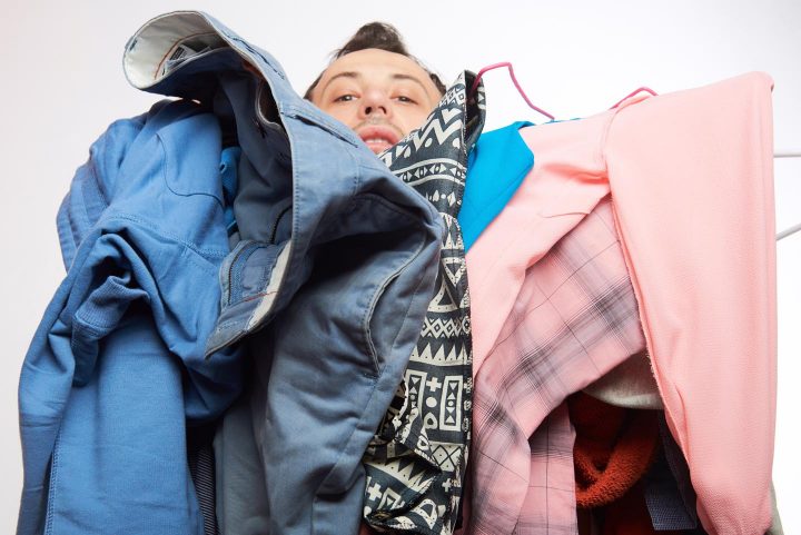 Een man vecht met een stapel kleren
